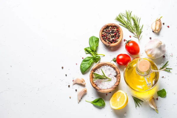 Spices, herbs and olive oil over white stone table. — Stock Photo, Image