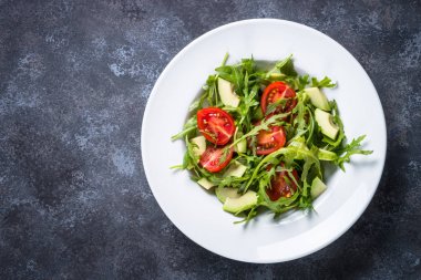 Sağlıklı vegan salata roka, avokado ve domates. 