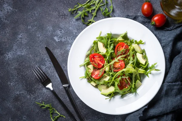 Salada vegan saudável de rúcula, abacate e tomate . — Fotografia de Stock