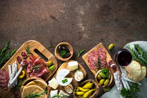 Antipasto delicatessen - meat, cheese, olives and wine on stone — Stock Photo, Image