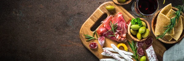 Antipasto - carne fatiada, presunto, salame, azeitonas e vista superior do vinho . — Fotografia de Stock