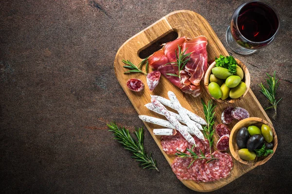 Antipasti - nakrájené maso, šunka, salám, olivy a víno pohled shora. — Stock fotografie