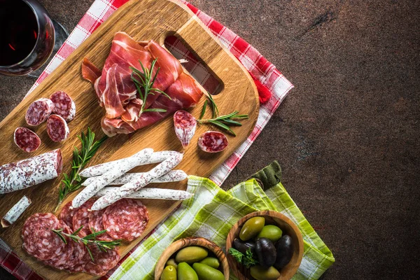 Antipasto - нарізане м'ясо, шинка, салямі, оливки та вид зверху на вино . — стокове фото