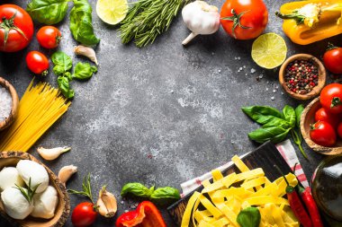 Makarna, domates, peynir, fesleğen ve zeytinyağı siyah taş tabl üzerinde