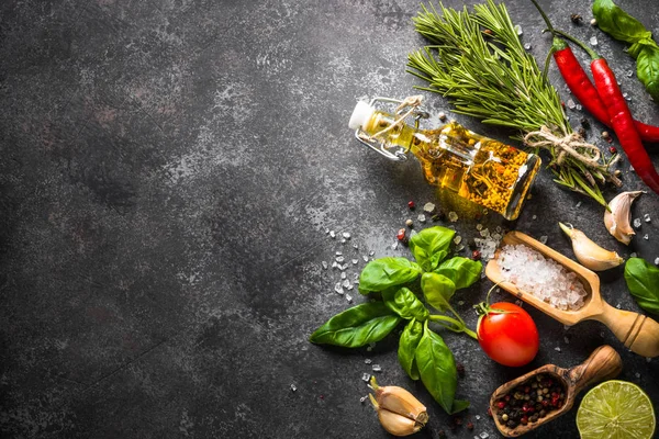 Spices and herbs over black stone table. 