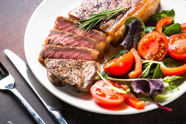 Bistecca di manzo striploin alla griglia con insalata in piatto . — Foto Stock