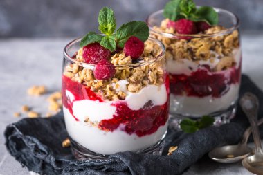 Katmanlı tatlı yoğurt, granola, reçel ve ahududu.