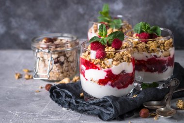 Katmanlı tatlı yoğurt, granola, reçel ve ahududu.