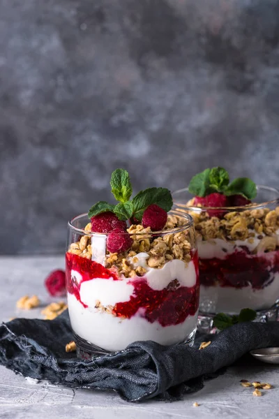 Layered dessert with yogurt, granola, jam and raspberries. — Stock Photo, Image