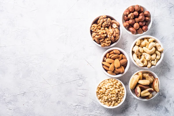 Nuts assortments on stone table top view. — Stock Photo, Image