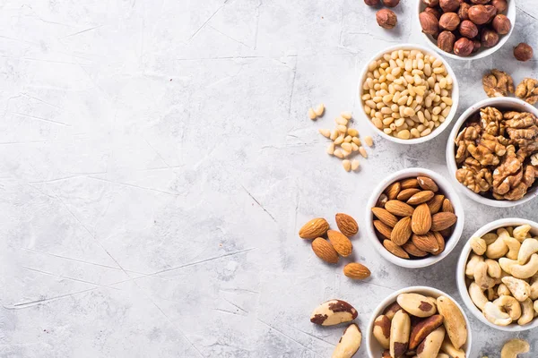 Nuts assortments on stone table top view. — Stock Photo, Image