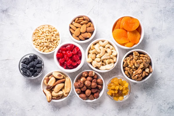 Nuts and dried fruits assortment on stone table top view. — Stock Photo, Image