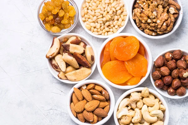 Nuts and dried fruits assortment on stone table top view. — Stock Photo, Image