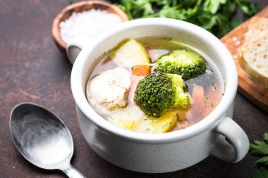 Karanlık masada tavuk ve sebze çorbası. 