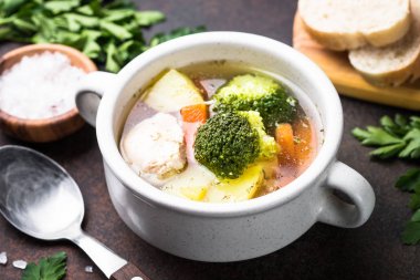 Karanlık masada tavuk ve sebze çorbası. 