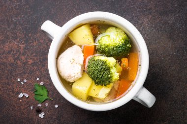 Karanlık masada tavuk ve sebze çorbası. 