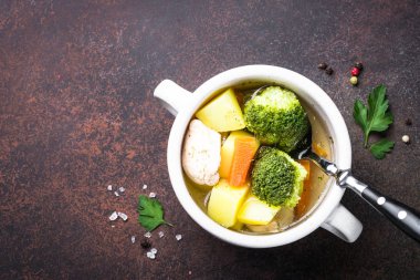 Karanlık masada tavuk ve sebze çorbası. 