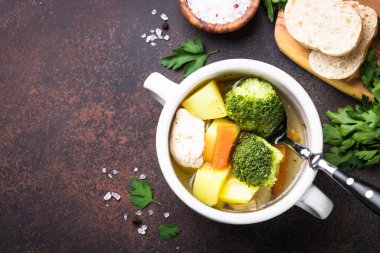 Karanlık masada tavuk ve sebze çorbası. 