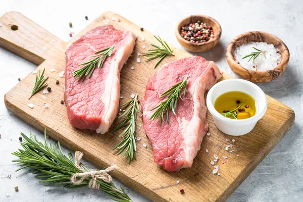 Kesme tahtası üzerinde ham sığır eti striploin biftek. — Stok fotoğraf