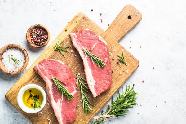Kesme tahtası üzerinde ham sığır eti striploin biftek. — Stok fotoğraf