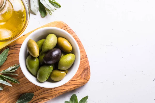 Olives and olive oil on white. — Stock Photo, Image