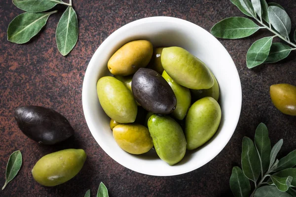 Aceitunas y aceite de oliva sobre mesa de piedra oscura vista superior . — Foto de Stock