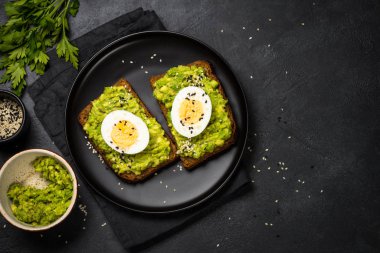 Siyah arkaplanda Avokado Sandviçleri.