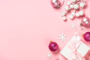Noel hediyesi kutusu ve pembe arka plandaki süslemeler.