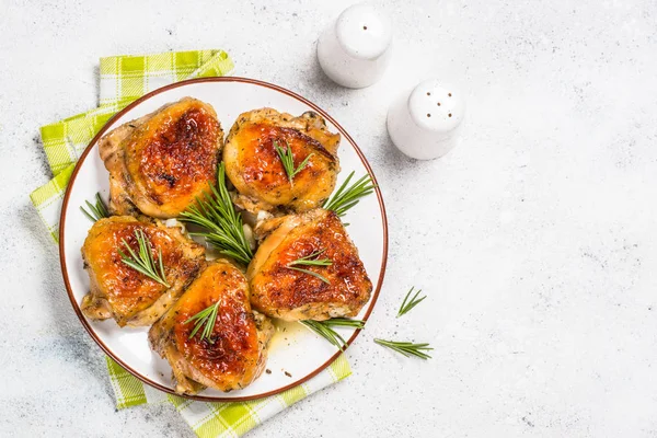Baked chicken thighs with herbs on white plate. — Stock Photo, Image
