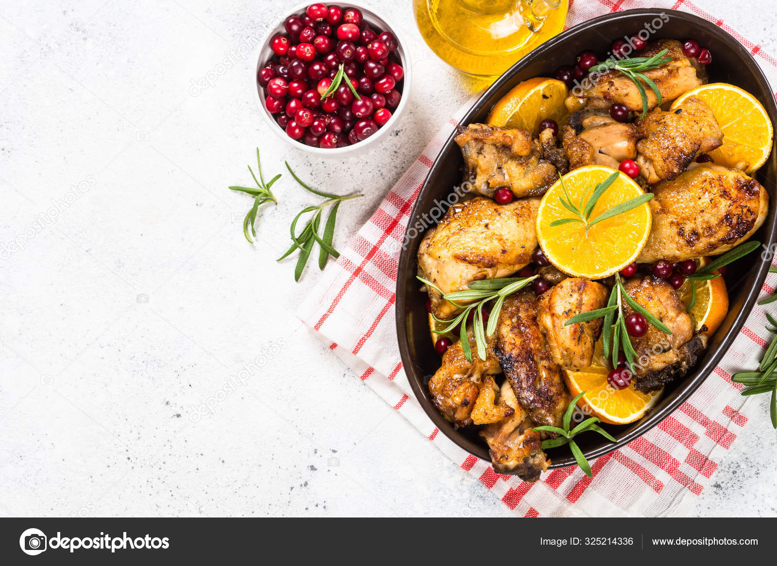 Baked chicken with orange, cranberry and rosemary. Stock Photo by