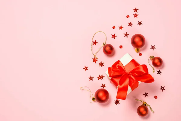 Fondo plano de Navidad sobre rosa con caja actual y decoraciones . —  Fotos de Stock