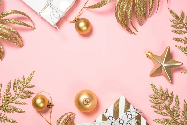 Golden Christmas flat lay background on pink with present box and decorations. — Stock Photo, Image