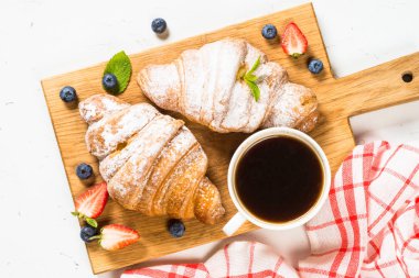 Taze böğürtlenli kruvasan ve bir fincan kahve.