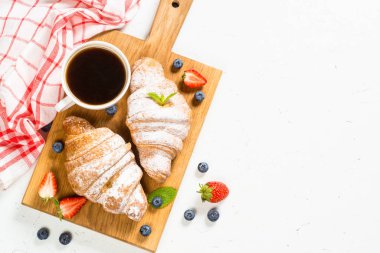 Taze böğürtlenli kruvasan ve bir fincan kahve.