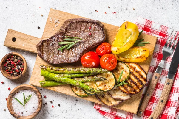 Carne grelhada com legumes na mesa de pedra branca . — Fotografia de Stock