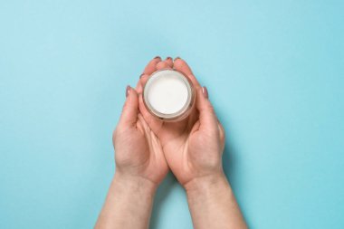 Mavi üzerine krema kullanan kadın.