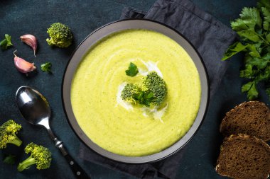 Brokoli kremalı çorba, karanlık masanın üstünde..