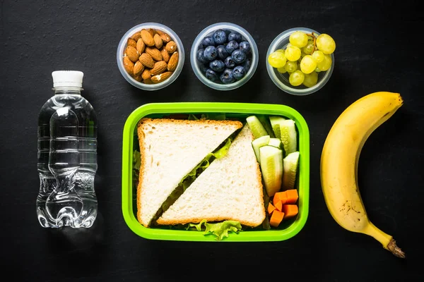 Lunch box z kanapką i owoców na czarno. — Zdjęcie stockowe