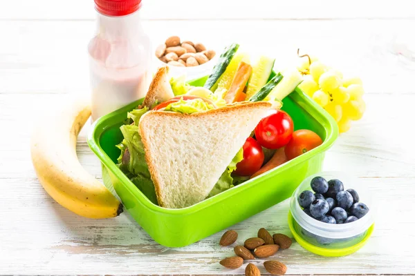 Обідня коробка з бутербродом, овочами, ягодами та горіхами . — стокове фото