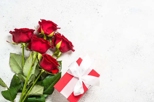 Fleur de roses rouges et boîte cadeau sur fond blanc vue de dessus . — Photo