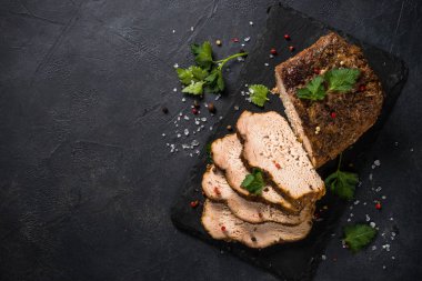 Pişmiş domuz etli jambon siyah mutfak masasında..