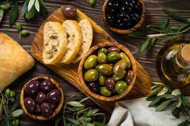 Zeytin, zeytin yağı ve ciabatta ahşap masada..