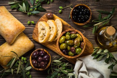 Zeytin, zeytin yağı ve ciabatta ahşap masada..