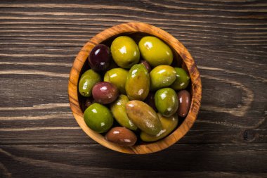 Ahşap masada siyah ve yeşil zeytin.