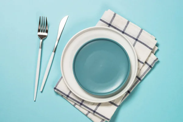 Table setting with white plate and cutlery on blue. — Stock Photo, Image