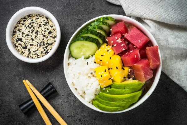 Tuna poke bowl on black background top view.