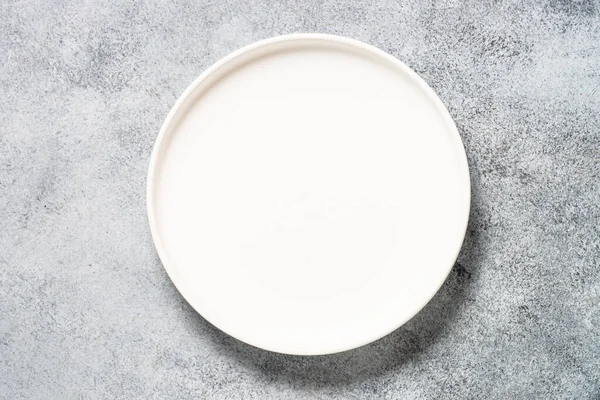 Kitchen table with white plate. — Stock Photo, Image