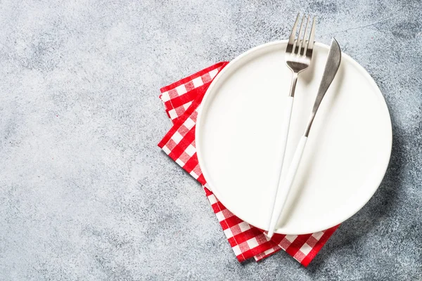 Table setting with white plate and cutlery top view. — Stockfoto