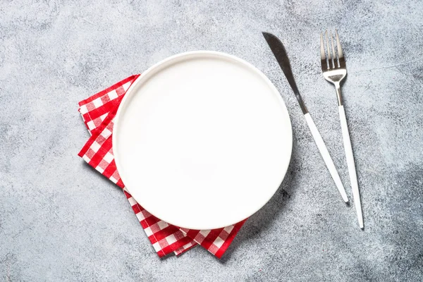 Table setting with white plate and cutlery top view. — Zdjęcie stockowe