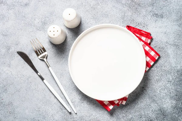 Table setting with white plate and cutlery top view. — Stockfoto